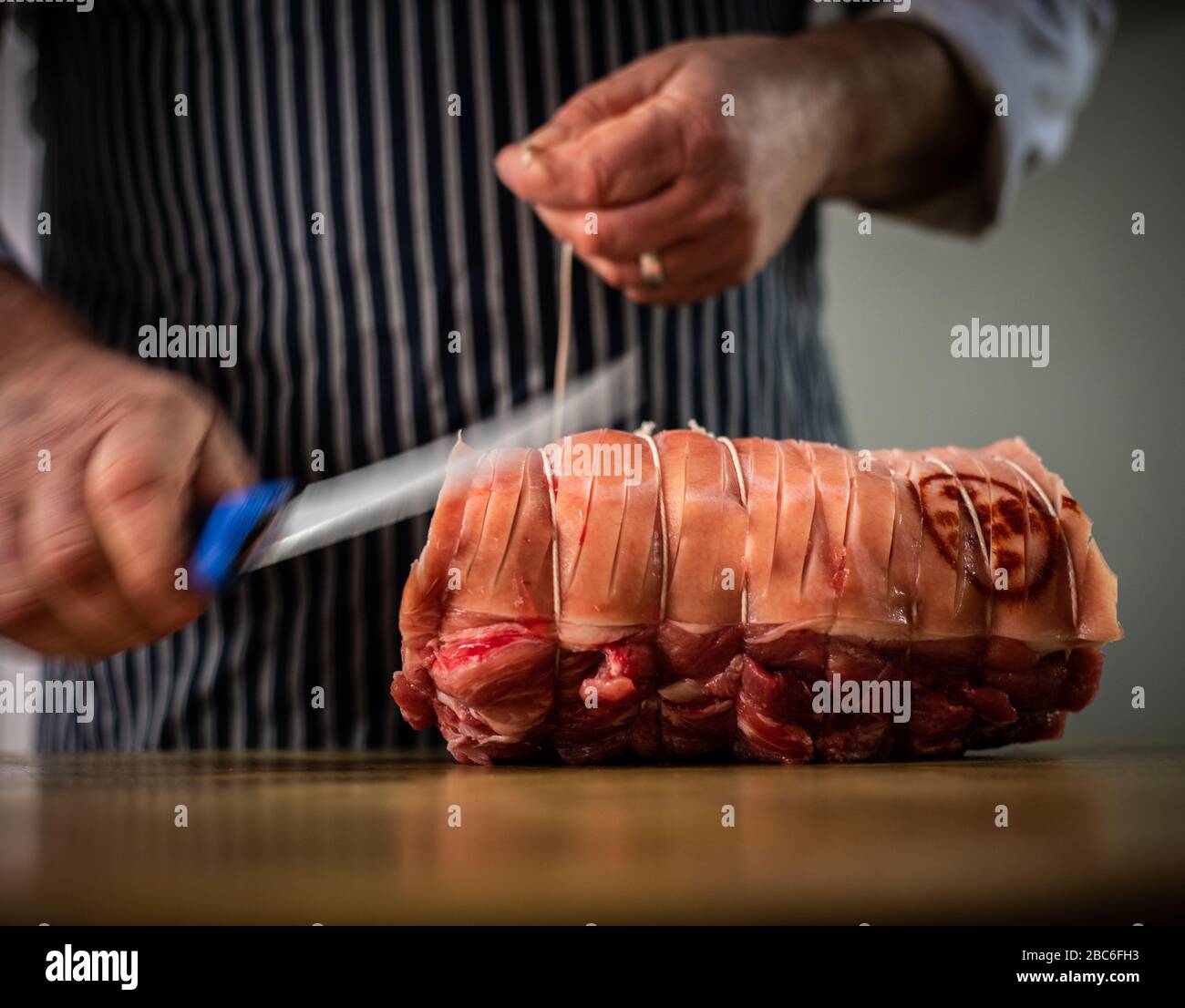 Preparazione di carne da un macellaio Foto Stock