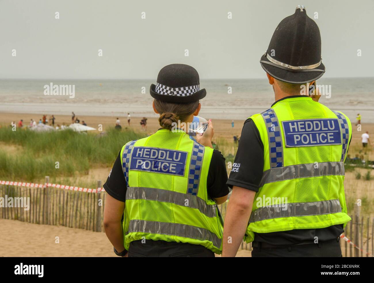 SWANSEA, GALLES - LUGLIO 2018: Poliziotti maschili e femminili in pattuglia sul lungomare di Swansea. Foto Stock