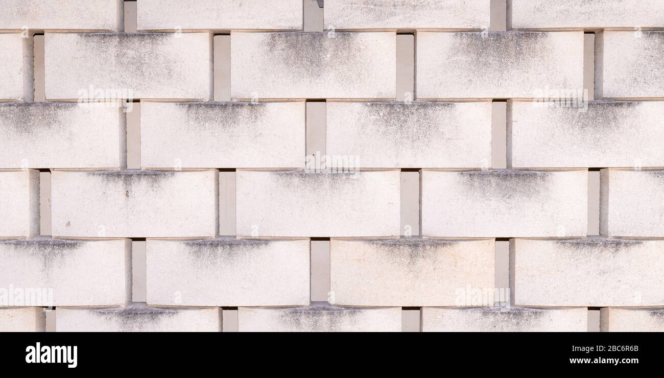 Calcestruzzo impilato piastrelle di pietra sfondo grigio cinder blocco parete grigio rivestimento carta parati senza cuciture texture Foto Stock