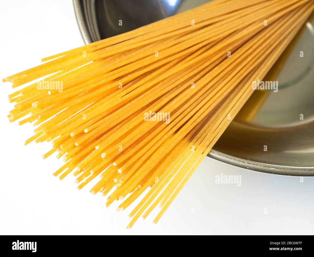 100 grammi di spaghetti di grano integrale in una ciotola di acciaio inossidabile su una tovaglia bianca Foto Stock