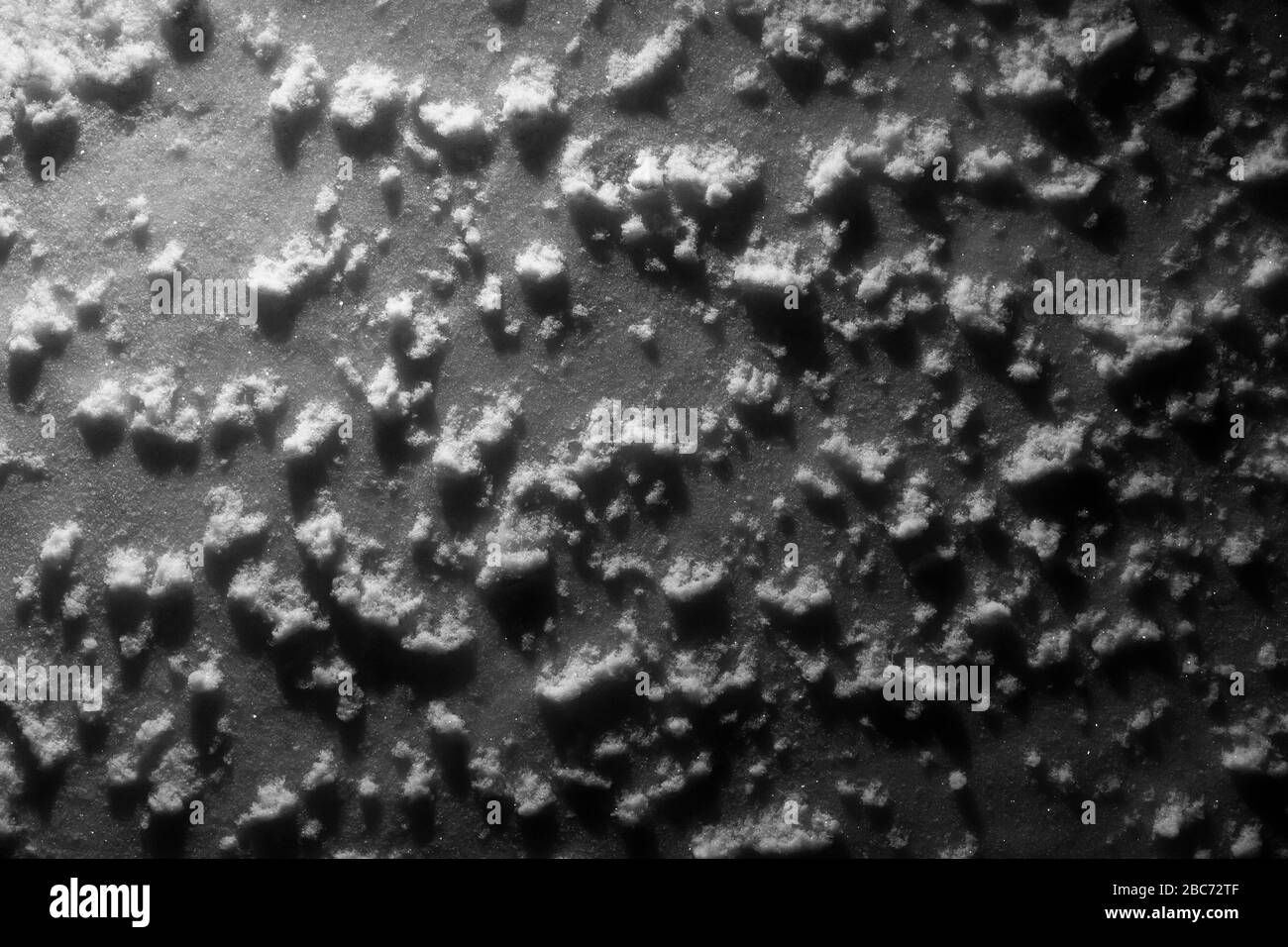 Superficie della neve sotto l'illuminazione artificiale come astrazione e primo piano di sfondo. Foto Stock