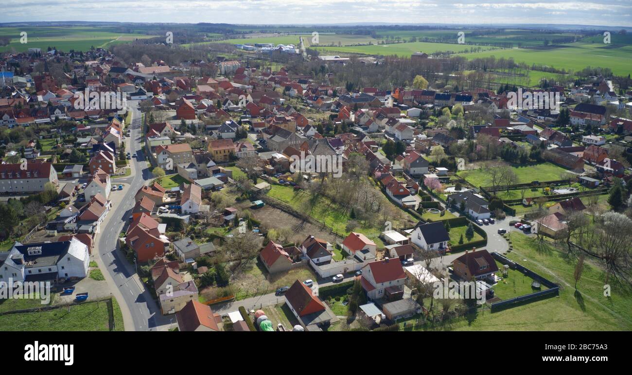 Veduta aerea di un piccolo villaggio in Germania al sole luminoso con molti giardini e prati, fiels e prati intorno Foto Stock