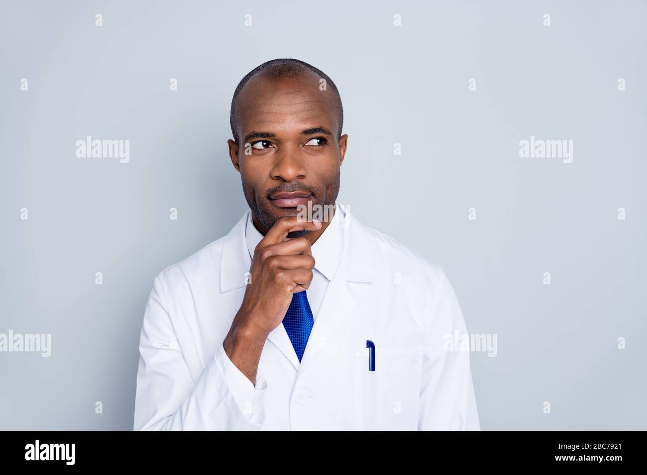 Foto del medico bel tipo di pelle scura pensare al virologo paziente diagnosi braccio mento esperimento guardare vuoto spazio indossare bianco camice da laboratorio cravatta blu collo Foto Stock