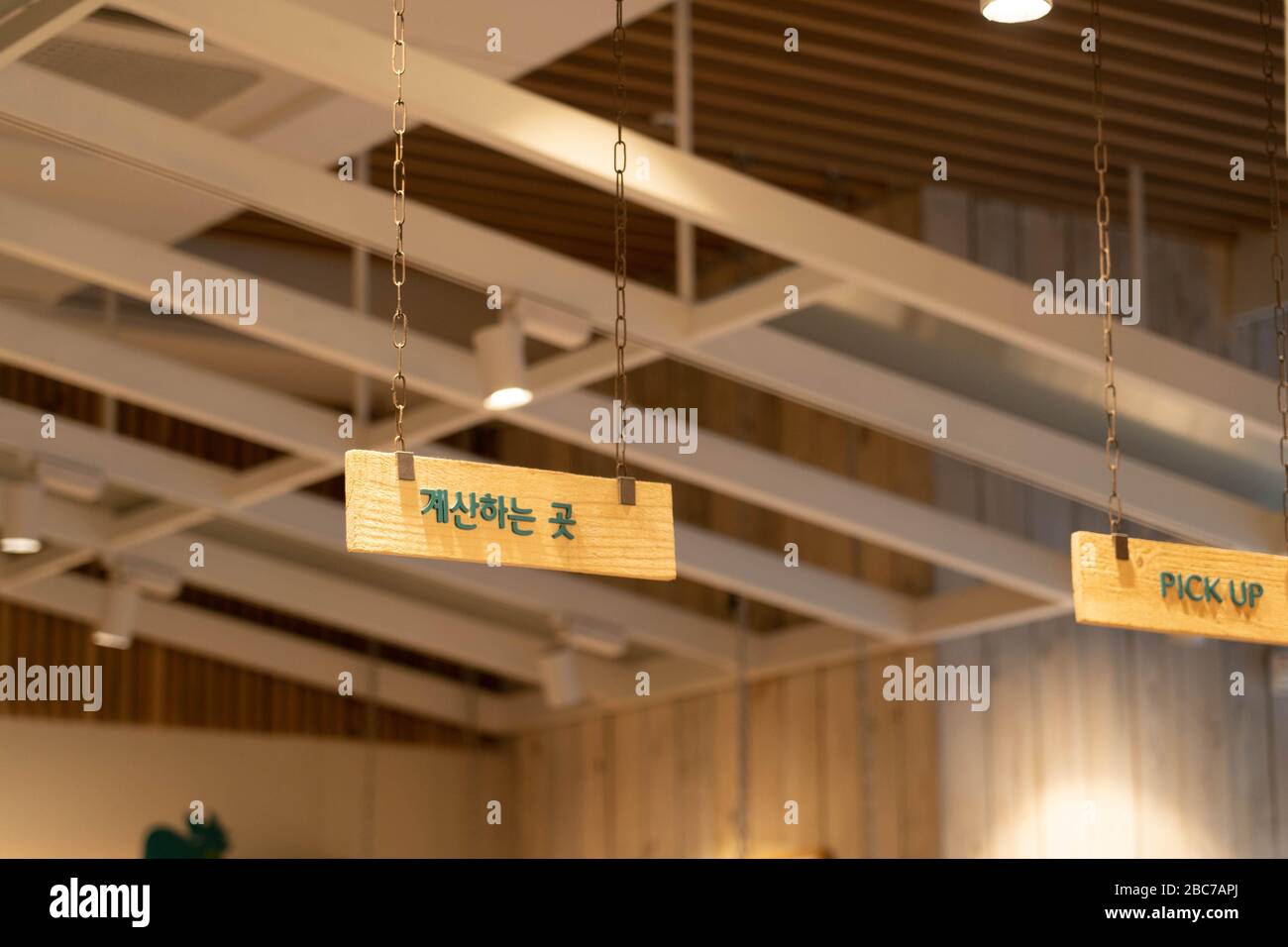 Cartello in legno con le informazioni appeso al soffitto. Cartello da banco in lingua coreana. Foto Stock