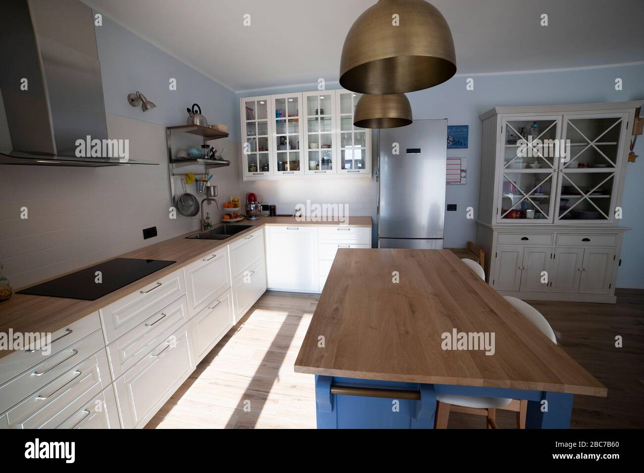 Sgabelli bianco a isola unità in un colore blu pallido la cucina con  pavimento in legno e le unità bianche Foto stock - Alamy