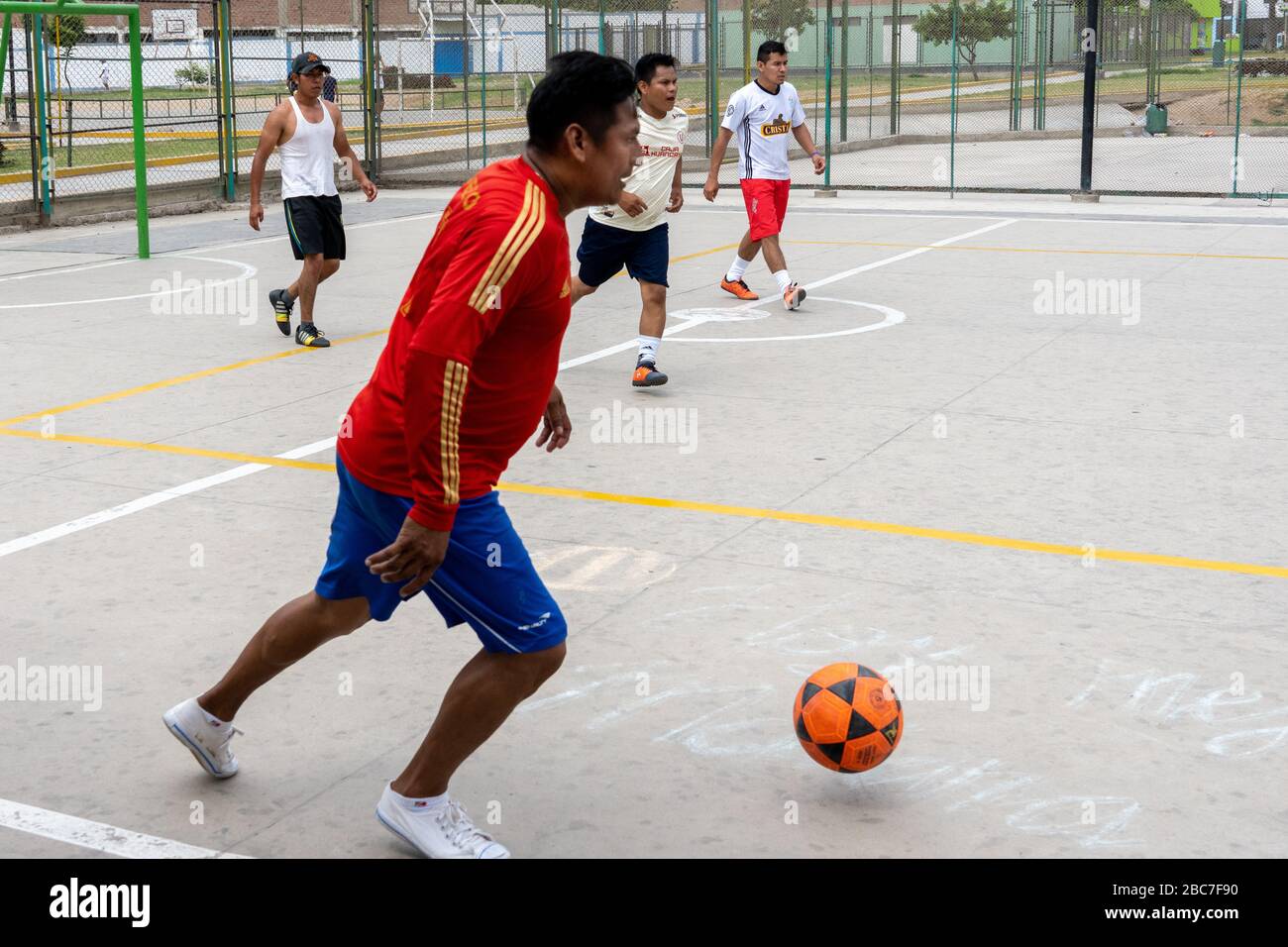 Amici peruviani da Iquitos giocano una partita di calcio Domenica pomeriggio a Lima, Perù Foto Stock