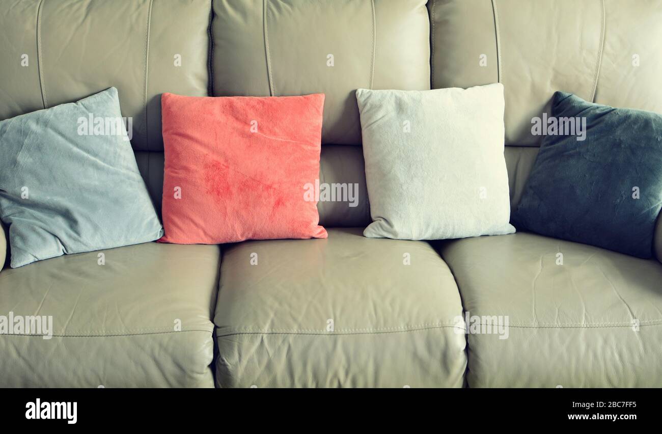 Foto a cornice di divano in pelle marrone chiaro con cuscini in pelle scamosciata di colore. Foto Stock