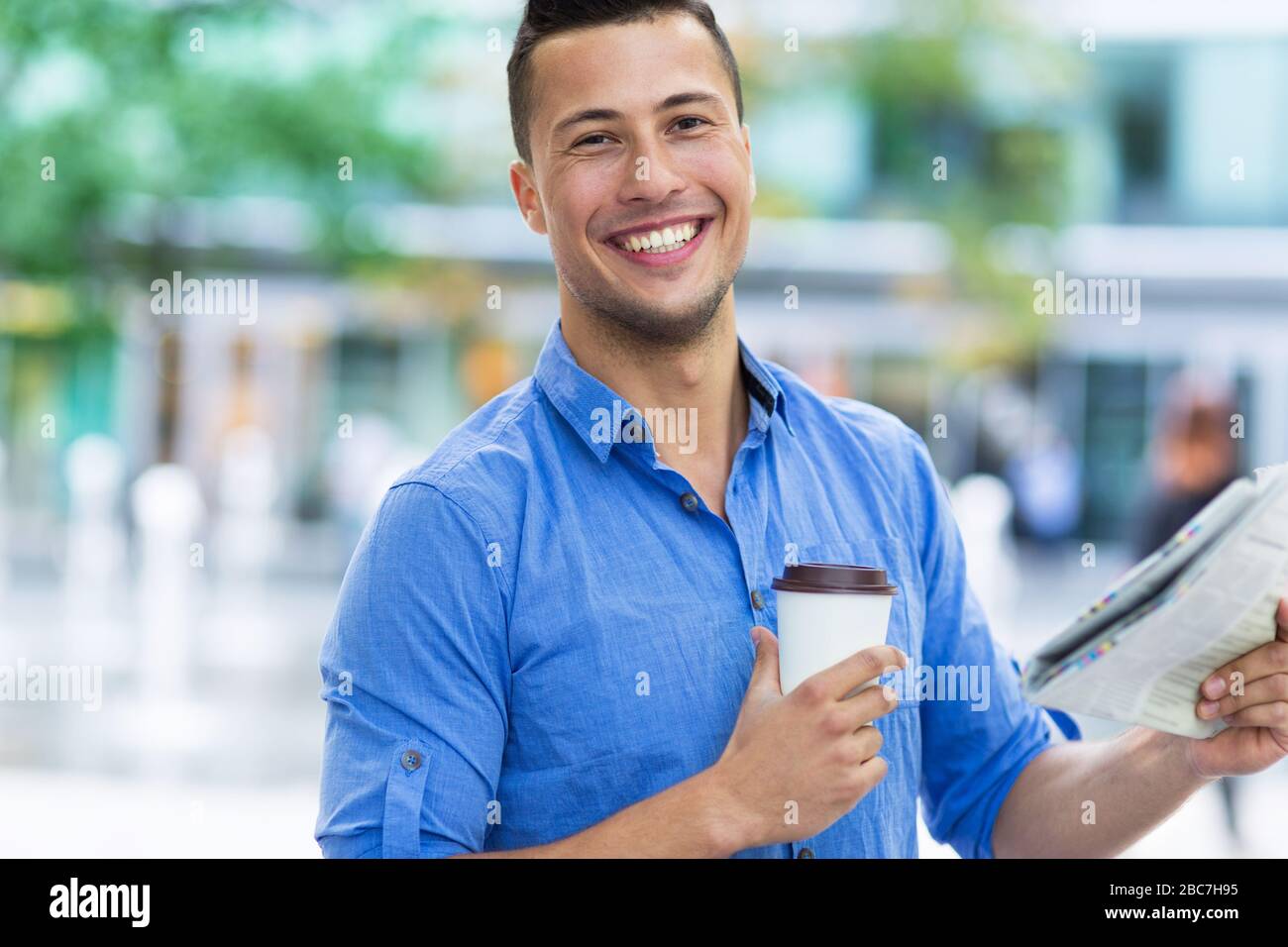 Uomo che tiene giornale e caffè Foto Stock