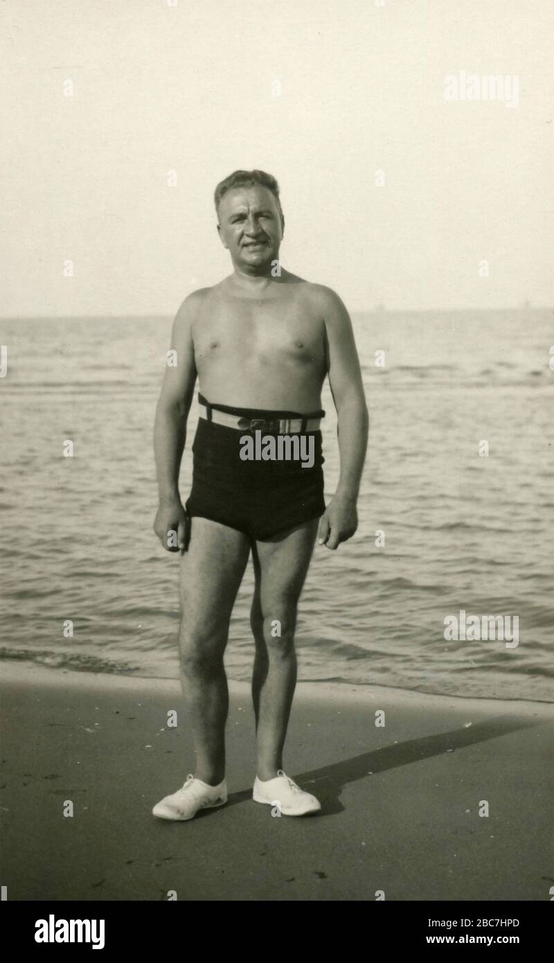 Uomo che indossa il costume da bagno sulla spiaggia, Italia anni '50 Foto  stock - Alamy