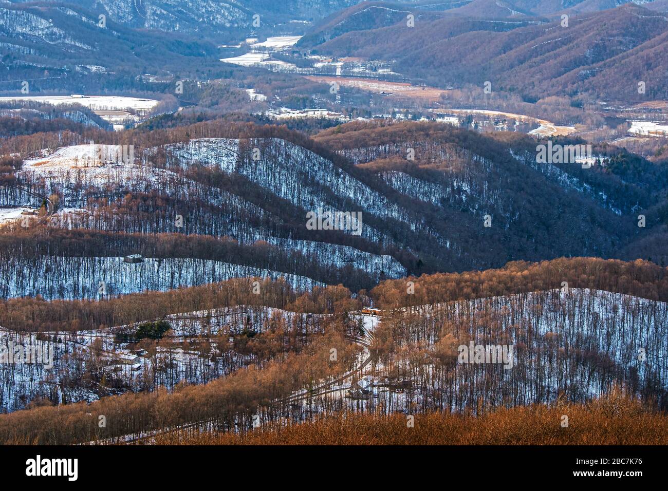 Le montagne innevate e le linee di cresta segnate da bastoni, rivelano un paesaggio che sembra essere inginocchiato e piegato su se stesso molte volte carv Foto Stock