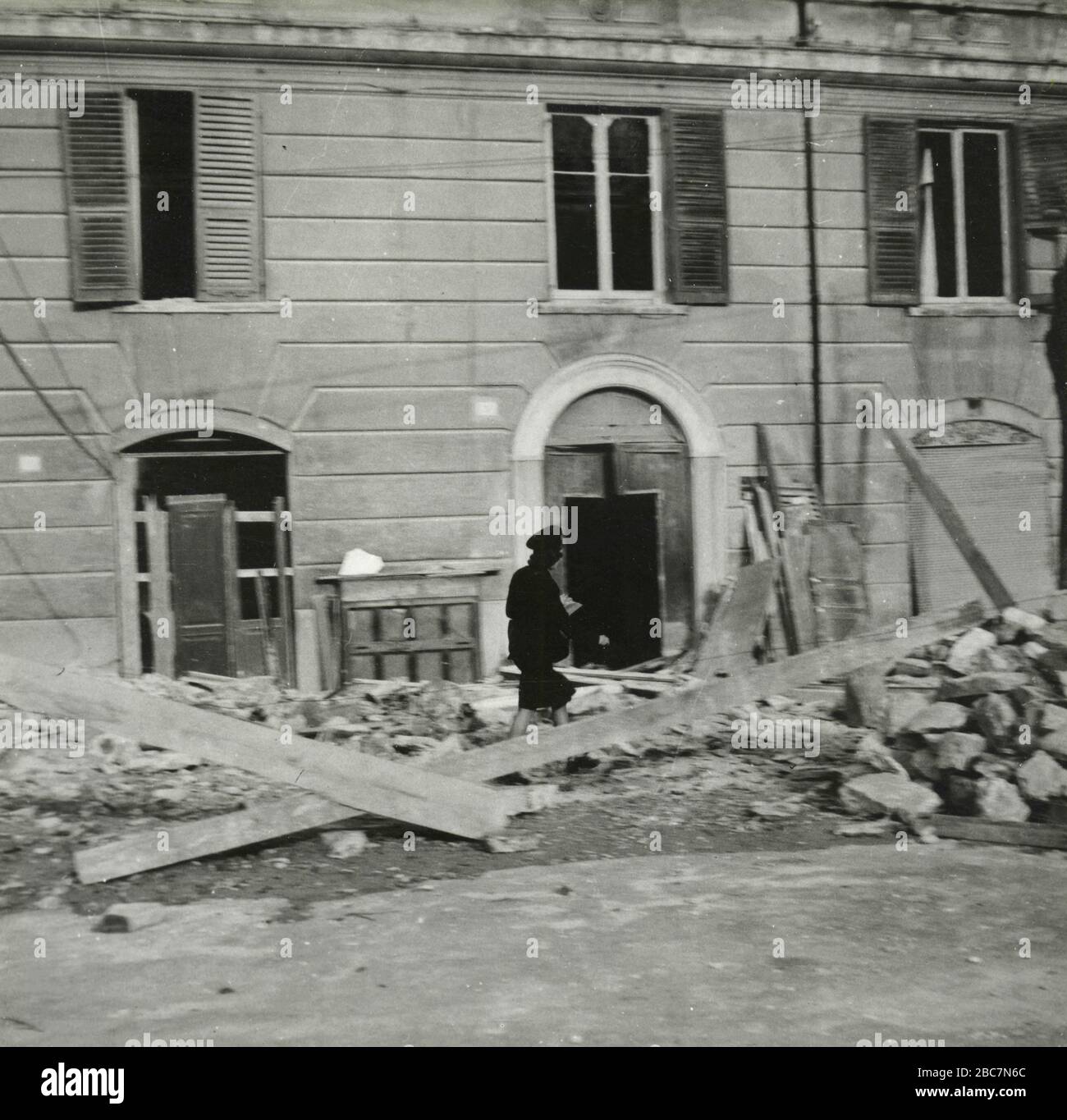 Postwoman che cerca di consegnare la posta a case bombardate, Roma, Italia 1945 Foto Stock