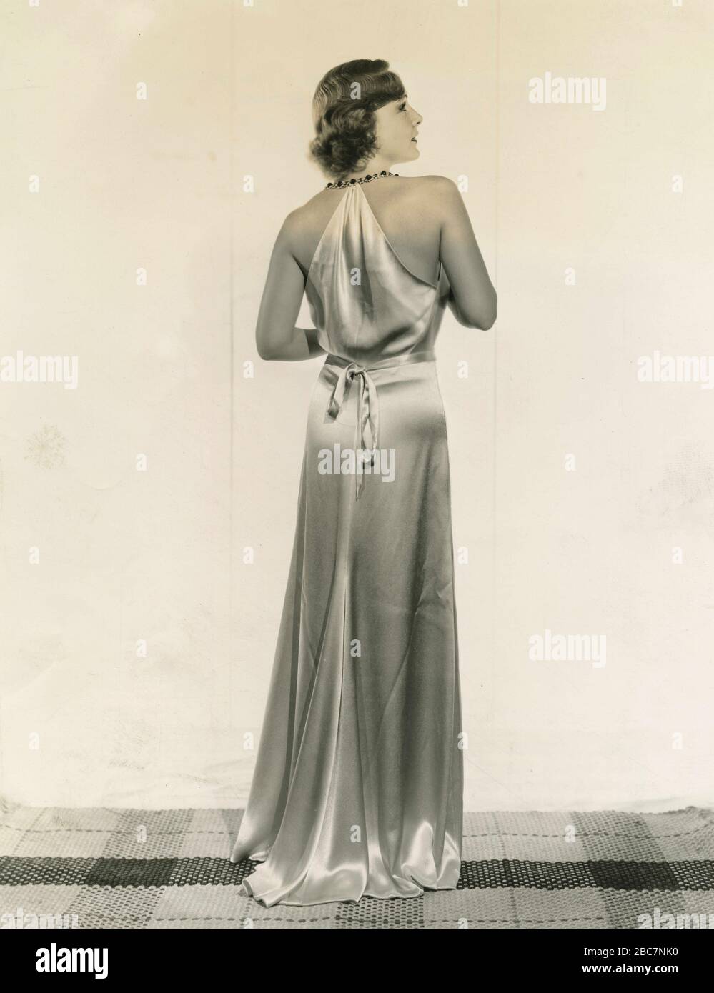 L'attrice americana Madge Evans indossa un lungo abito in raso, USA 1930 Foto Stock