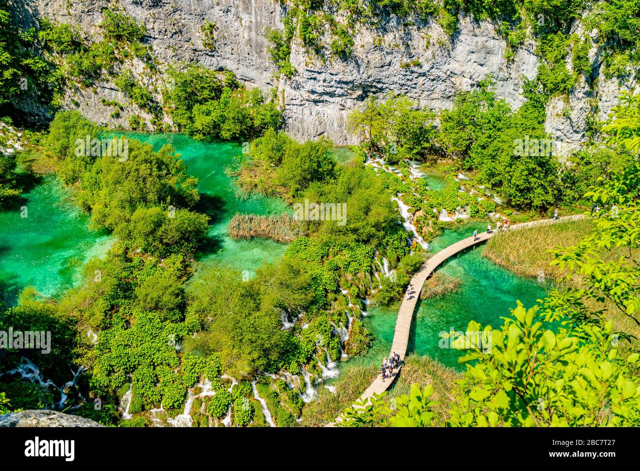 Ammira il passaggio pedonale che passa attraverso le cascate tufacee e le piscine turchesi nel Parco Nazionale dei Laghi di Plitvice, Croazia. Maggio 2017. Foto Stock