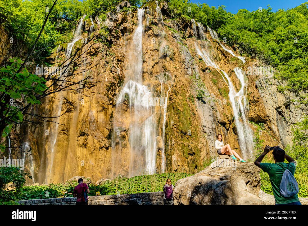 I turisti che scattano una foto di fronte al Veliki Slap, la più grande cascata del Parco Nazionale dei Laghi di Plitvice, Croazia, Europa. Maggio 2017. Foto Stock