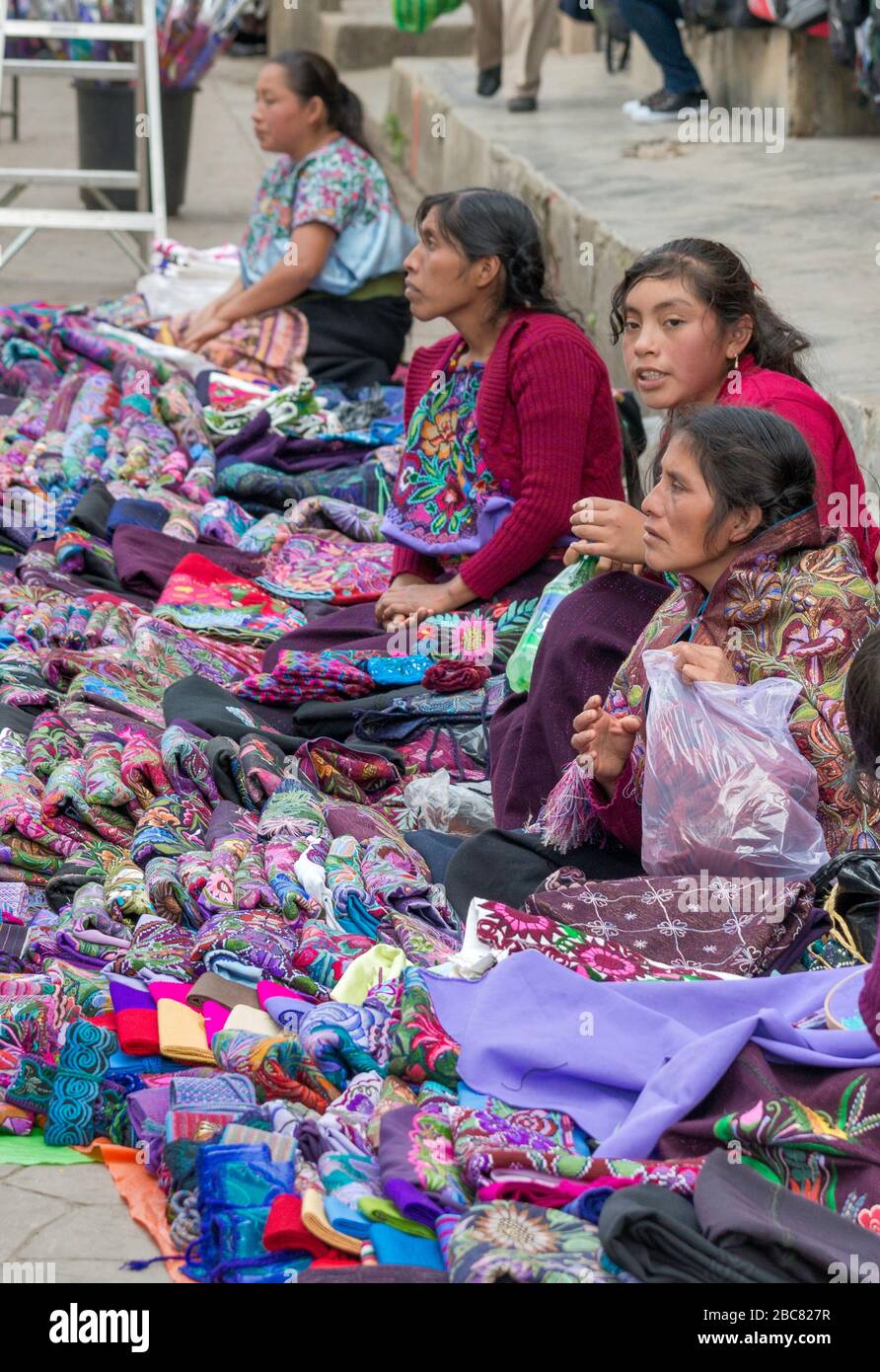Maya donne che vendono scialli seduti su strada marciapiede in Calle General Utrilla a San Cristobal de las Casas, Chiapas, Messico Foto Stock