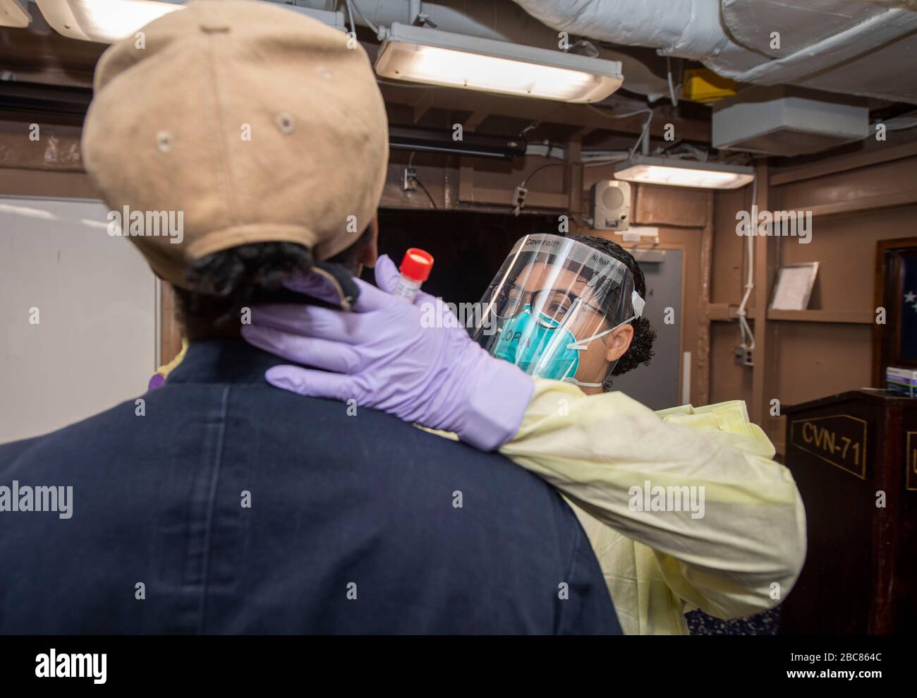 U.S. Navy Hospital Corpsman 3rd classe Ambar Lora, prende un campione di tampone per i test COVID-19 a bordo della portaerei USS Theodore Roosevelt 1 aprile 2020 a Apra Harbour, Guam. Il comandante delle navi, Capt Brett Crozier, è stato sollevato dal dazio il 31 marzo 2020 dopo aver chiesto di intervenire per contribuire a arginare la diffusione dei casi COVID-19 sulla sua nave. Foto Stock