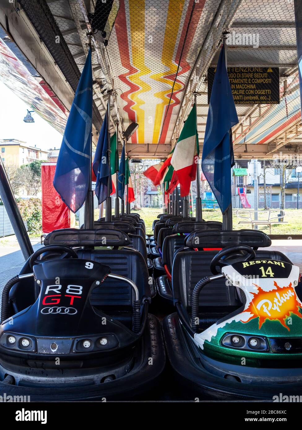 AULLA, ITALIA - 12 febbraio 2020: File di Dodgem aka Bumper Cars parcheggiate nel Fun Fair Amusement Park. Con bandiera italiana. Foto Stock