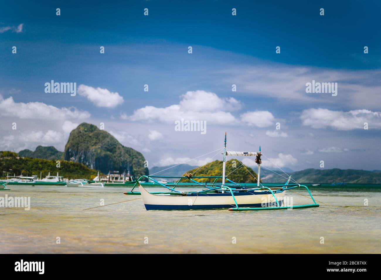 Tradizionale barca di pescatori banca in laguna poco profonda sulla spiaggia di Corong. Nido, Filippine. Cielo blu e nuvole sopra l'arcipelago di Bacuit. Foto Stock