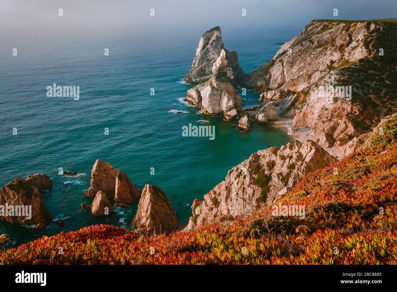 Rocce torreggianti surreali e bizzarre a Praia da Ursa Beach, Sintra, Portogallo in serata fuoco dorato luce del tramonto. Costa atlantica vicino al famoso Cabo da Ro Foto Stock