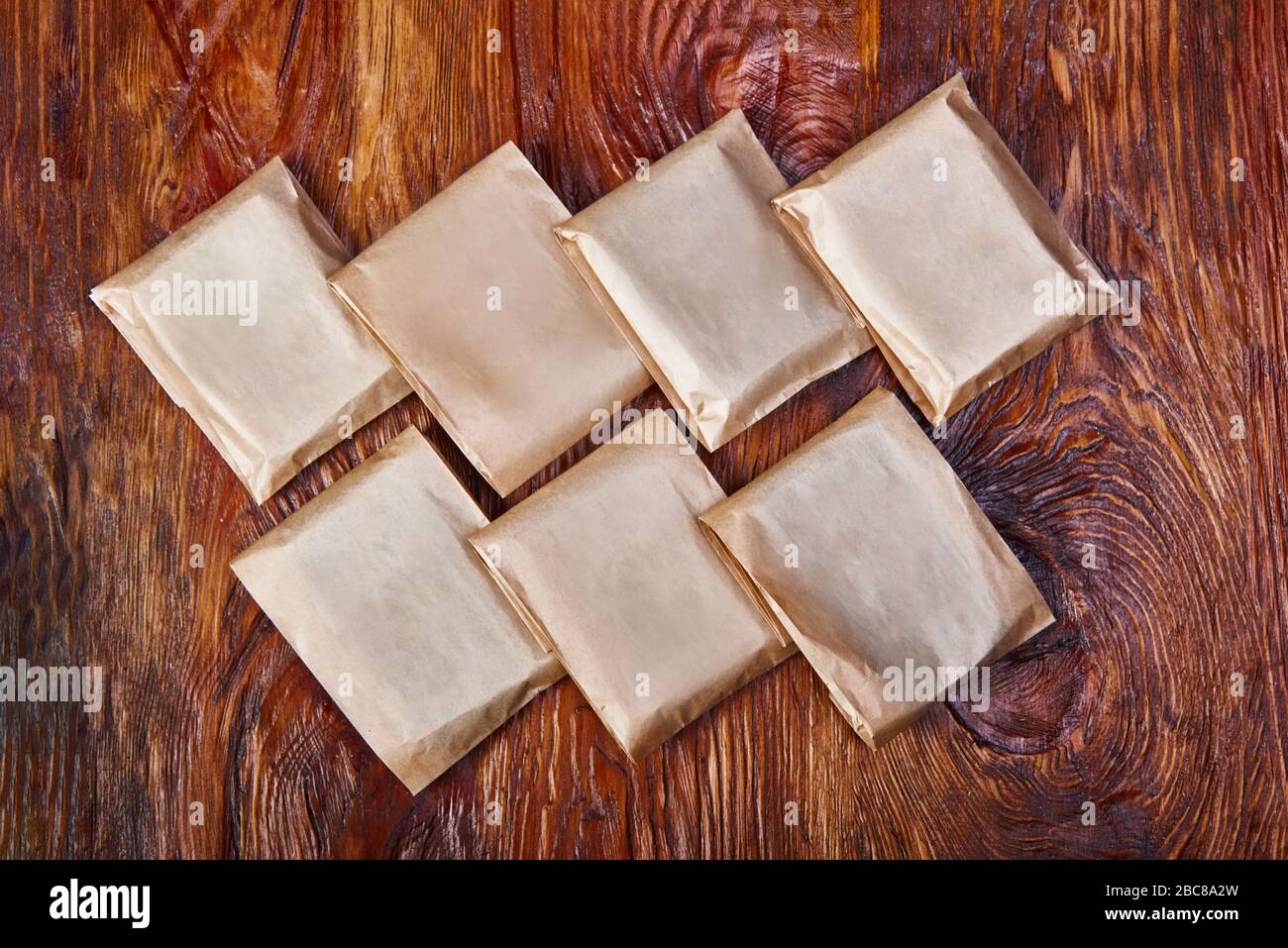 Saponette fatte a mano su asse di legno. Per il sapone, creare un imballaggio di carta ecologica. Mettere a posto il sapone naturale su una tavola di legno Foto Stock