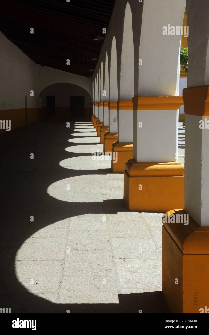 Ciudad Rodrigo, Salamanca District, Estremadura, Castilla y Leon, Spagna. Bianco lavaggio e archi gialli e ombre sotto la Chiesa di Cerralbo. Foto Stock