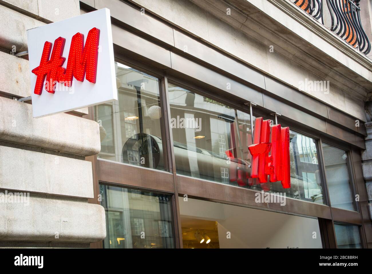 Negozio H&M - marchio britannico di alta moda Street - logo esterno / segnaletica - Londra Foto Stock