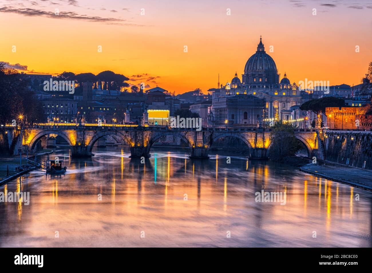 La Basilica di San Pietro nella Città del Vaticano e il Tevere dopo il tramonto Foto Stock