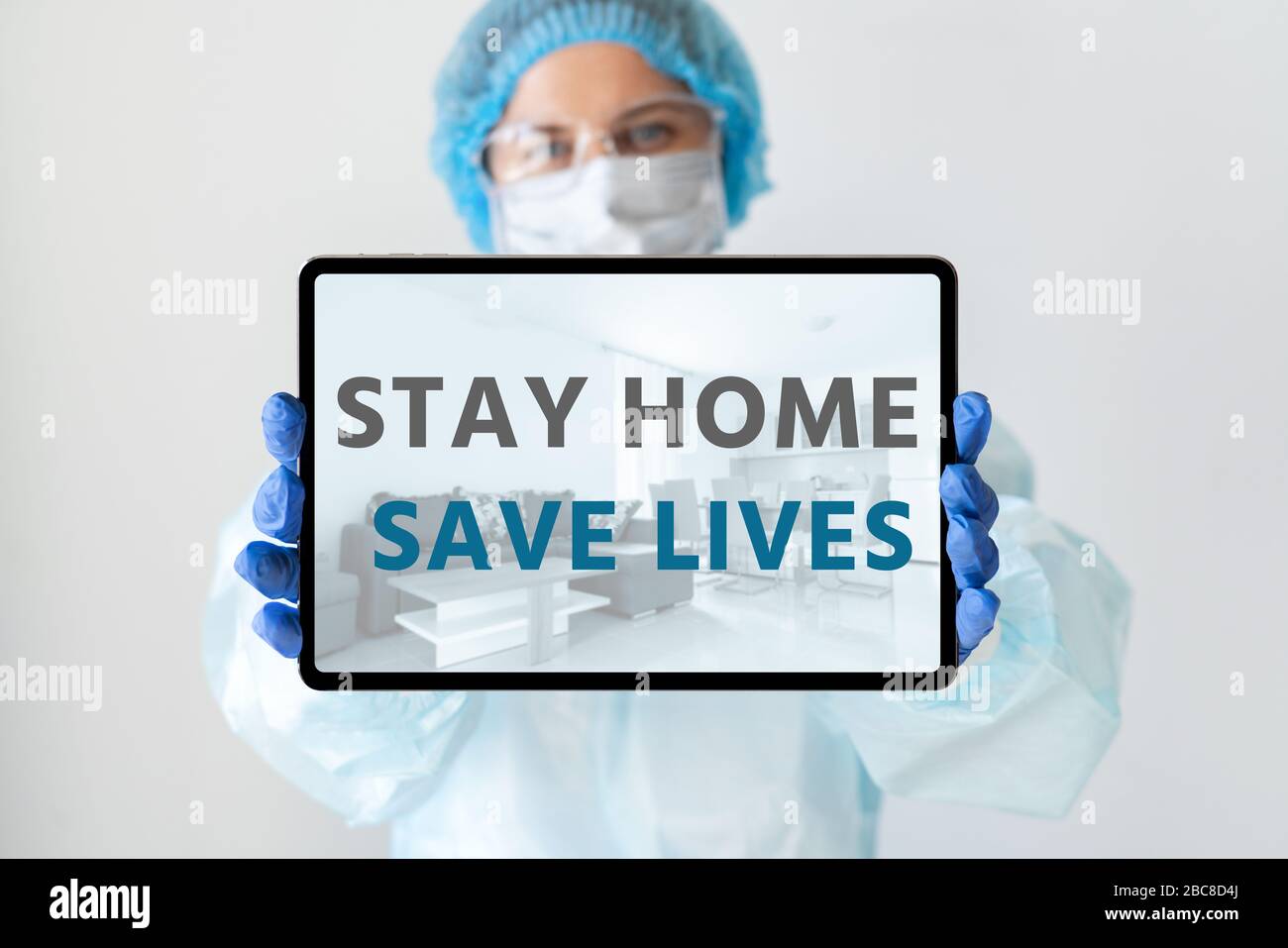 Dottore con un tablet digitale. Iscrizione a schermo "Say home Save Lives" Foto Stock