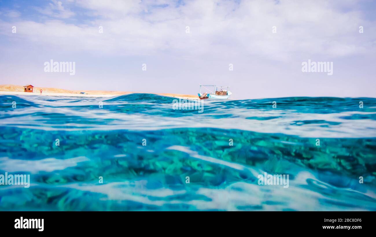 Superficie del Mar Rosso in Marsa Alam, Fisher Boat e Desert in background. Foto Stock