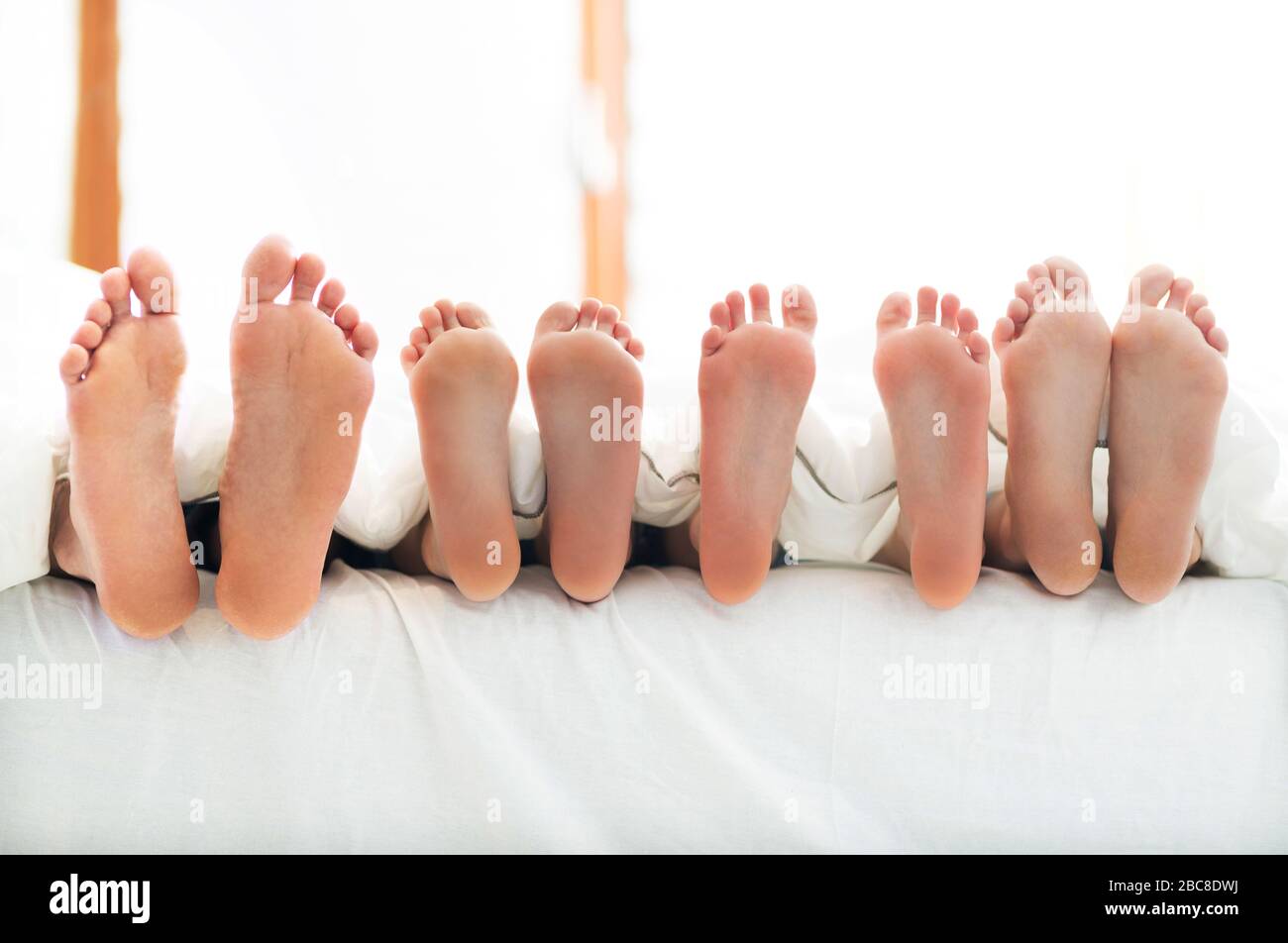Piedi di famiglia a letto Foto Stock