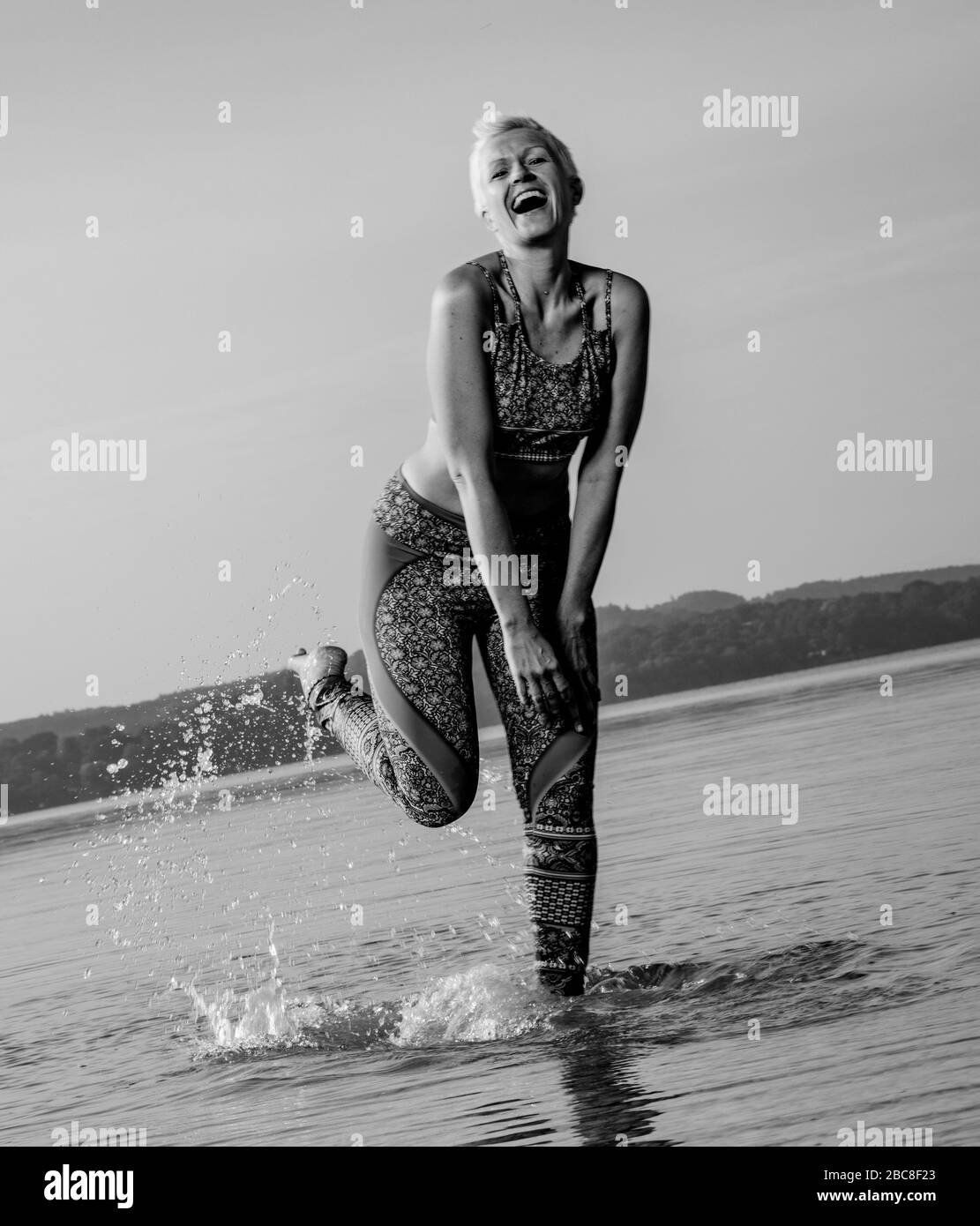 Meditazione IKYA, donna in abbigliamento sportivo allegramente sul lago Foto Stock