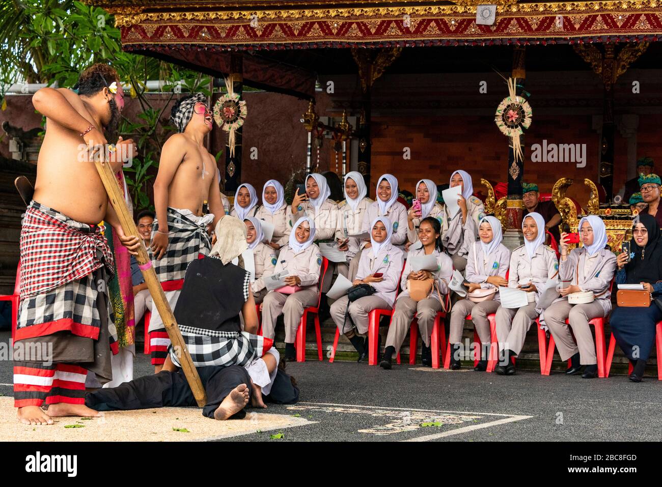 Vista orizzontale del pubblico ridendo i clown personaggi nella danza Barong a Bali, Indonesia. Foto Stock