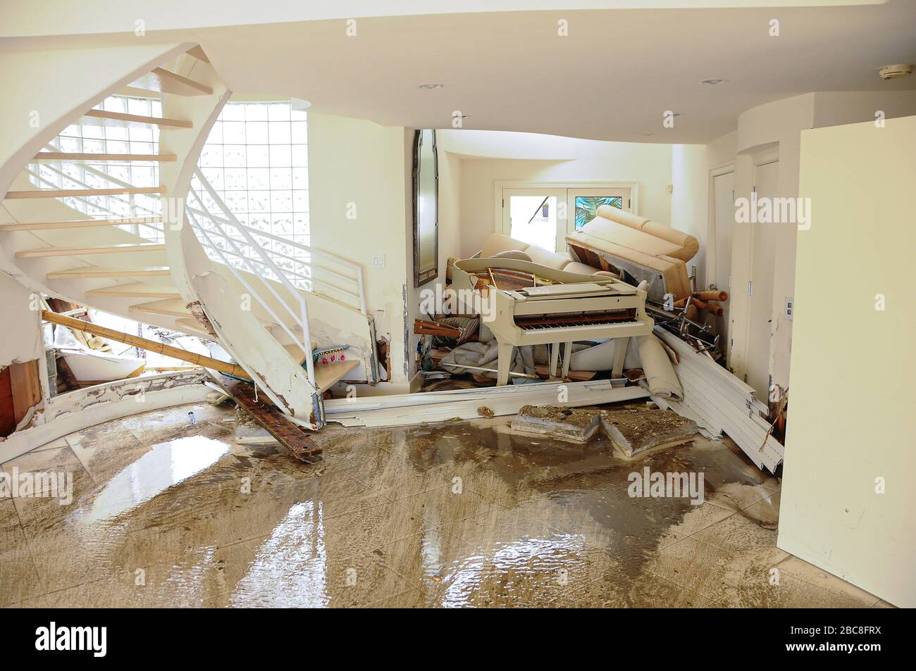 Una casa è devastata dall'uragano Sandy. Le acque alluvionali dell'oceano si sono schiantate attraverso la casa spingendo tutti i mobili e un pianoforte contro il muro. Foto Stock