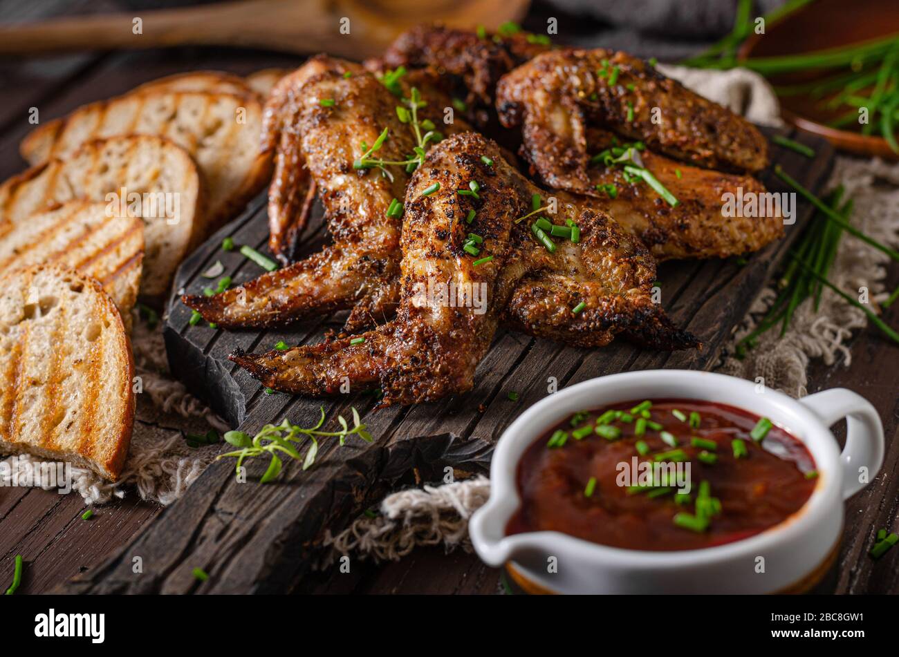 Deliziose ali alla griglia con salsa al barbecue e pane alla griglia Foto Stock