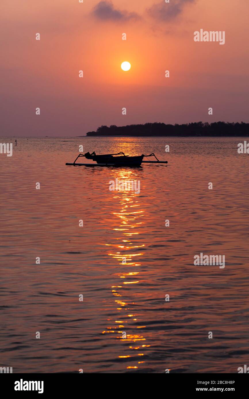 Asia, Indonesia, West Nusa Tenggara, Gili Air, Tramonto su Gili Meno con Barca tradizionale Outrigger Foto Stock
