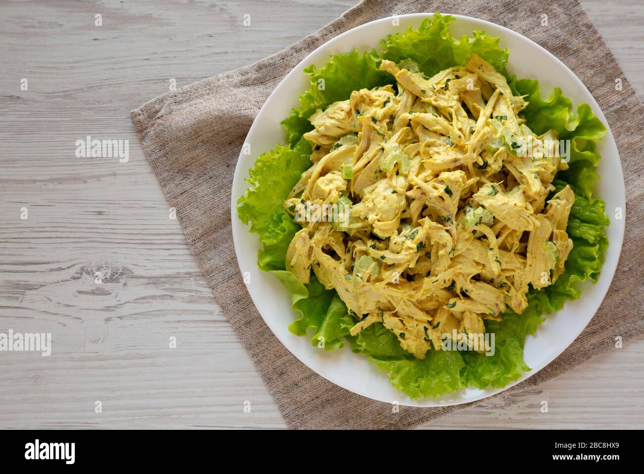 Insalata di pollo al Coronation fatta in casa su un piatto bianco, vista dall'alto. Disposizione piatta, dall'alto, vista dall'alto. Spazio di copia. Foto Stock