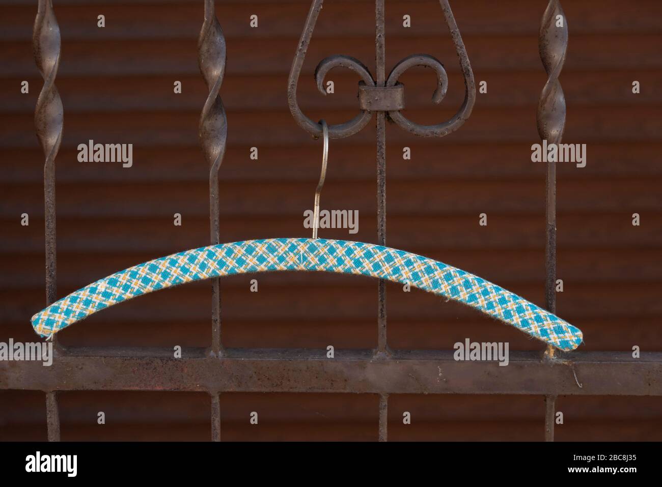 Un gancio appende su una griglia metallica Foto Stock