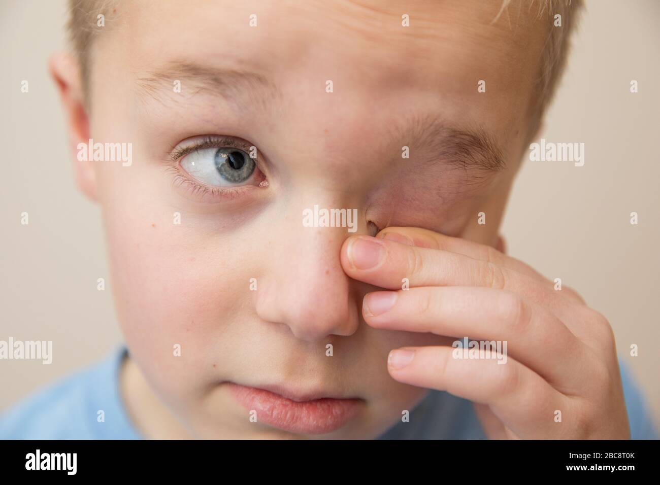 Bambino strofinando gli occhi con le dita Foto Stock