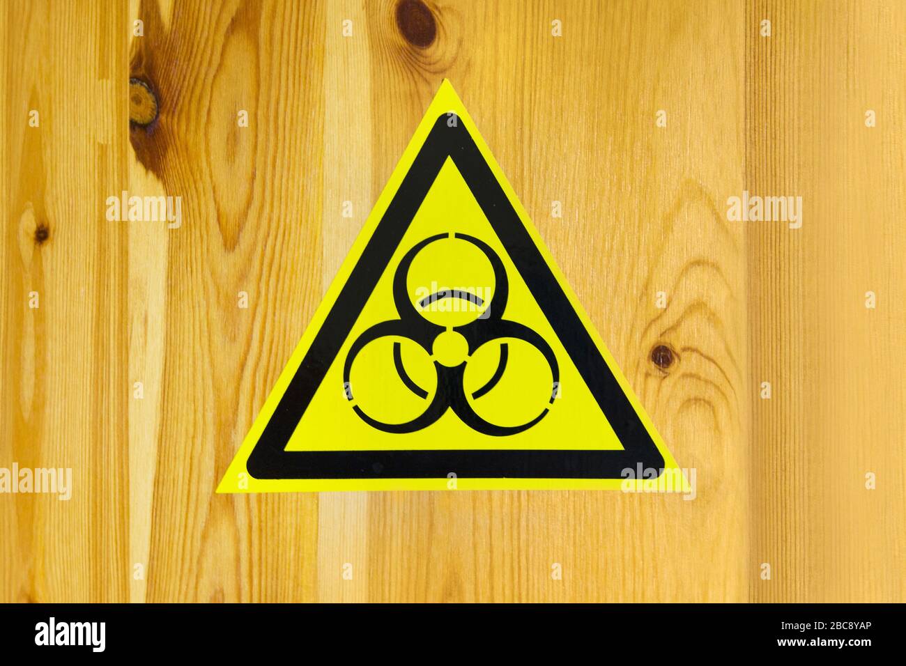 segno di pericolo biologico e armi biologiche per iscrizioni di avvertimento. adesivo su sfondo in legno. Foto Stock