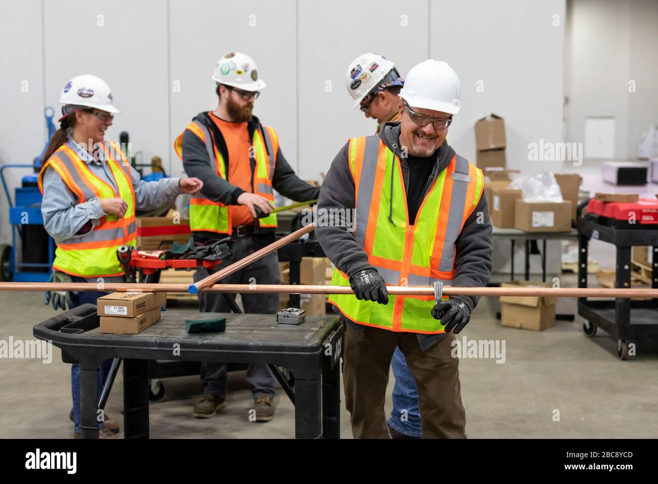 Detroit, Michigan, Stati Uniti. 2 aprile 2020. I lavoratori costruiscono un ospedale di emergenza presso il centro congressi TCF. L'ospedale a 1,000 letti si occuperà dei pazienti con Covid-19. I pipefitters tagliano il tubo per un sistema di alimentazione dell'ossigeno. Non tutti praticavano le distanze sociali. Credit: Jim West/Alamy Live News Foto Stock