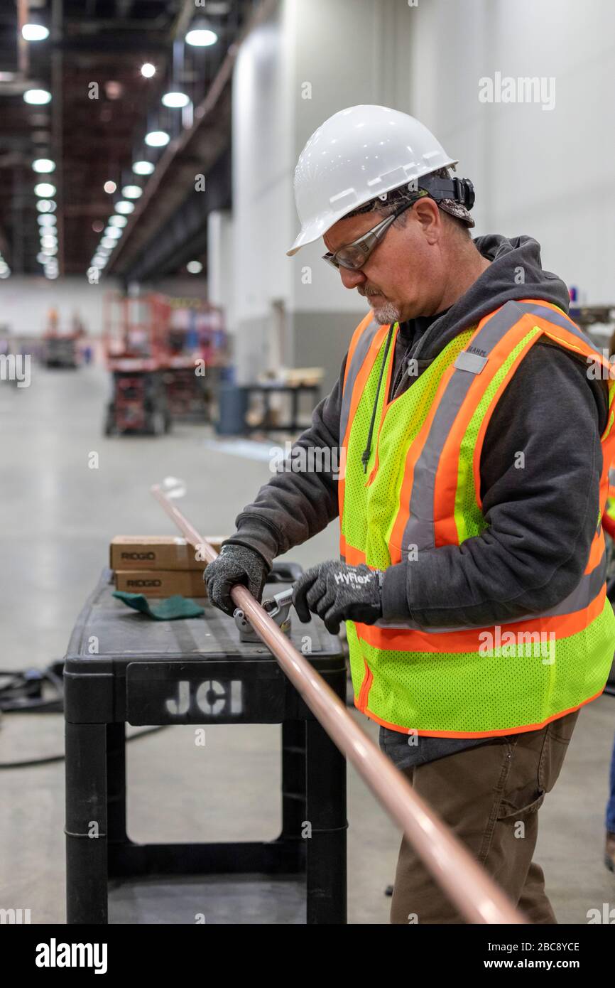 Detroit, Michigan, Stati Uniti. 2 aprile 2020. I lavoratori costruiscono un ospedale di emergenza presso il centro congressi TCF. L'ospedale a 1,000 letti si occuperà dei pazienti con Covid-19. Un raccordo taglia il tubo per un sistema di alimentazione dell'ossigeno. Credit: Jim West/Alamy Live News Foto Stock