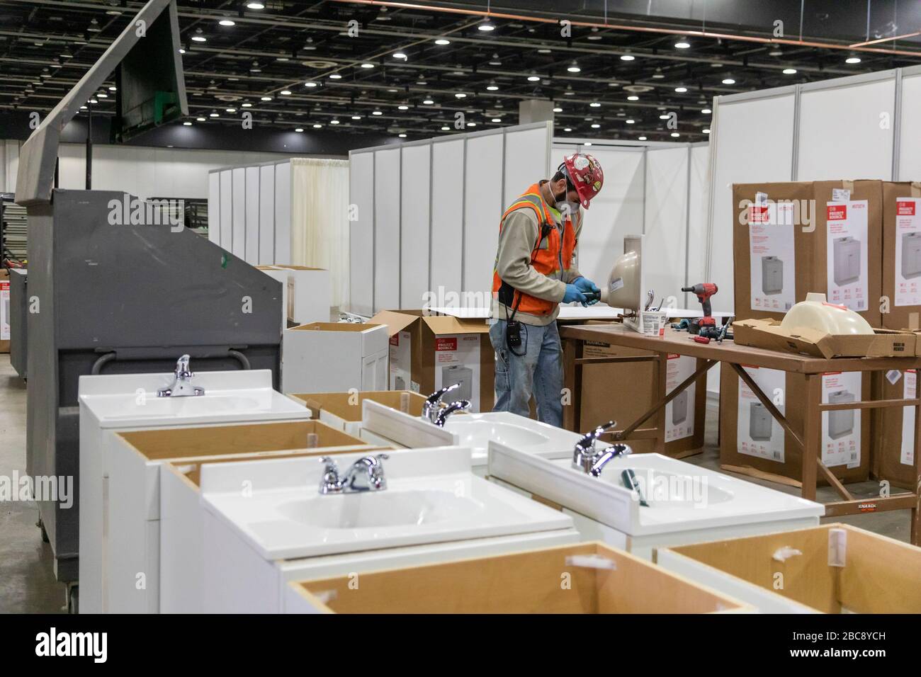 Detroit, Michigan, Stati Uniti. 2nd Apr, 2020. I lavoratori costruiscono un ospedale sul campo di emergenza presso il centro congressi TCF. L'ospedale di 1.000 posti letto si occuperà dei pazienti di Covid-19. Un idraulico mette insieme lavelli per stazioni di lavaggio a mano. Credito: Jim West/Alamy Live News Foto Stock
