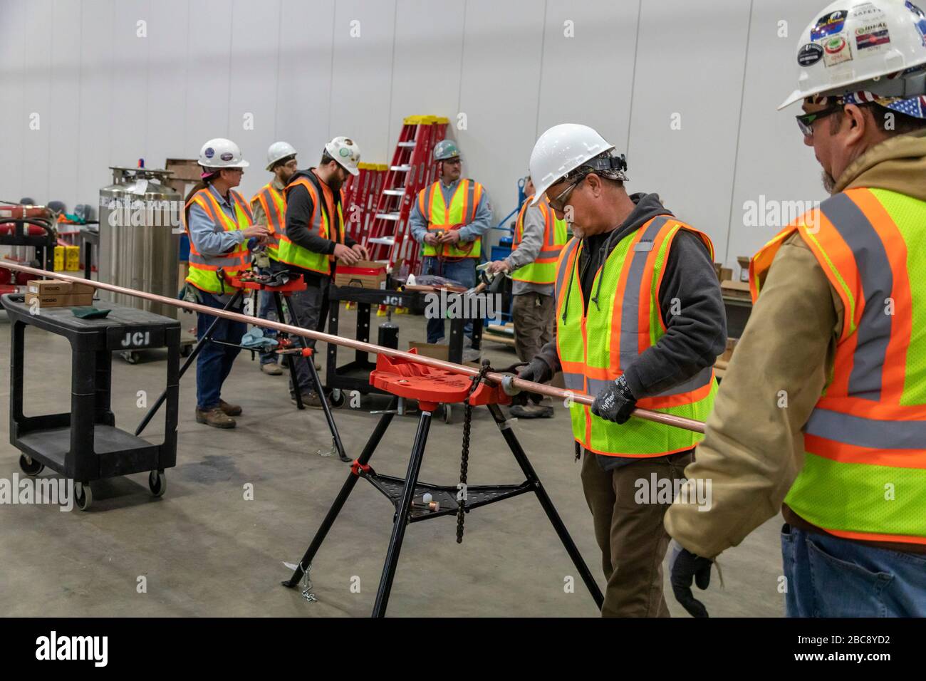 Detroit, Michigan, Stati Uniti. 2 aprile 2020. I lavoratori costruiscono un ospedale di emergenza presso il centro congressi TCF. L'ospedale a 1,000 letti si occuperà dei pazienti con Covid-19. I pipefitters tagliano il tubo per un sistema di alimentazione dell'ossigeno. Non tutti praticavano le distanze sociali. Credit: Jim West/Alamy Live News Foto Stock