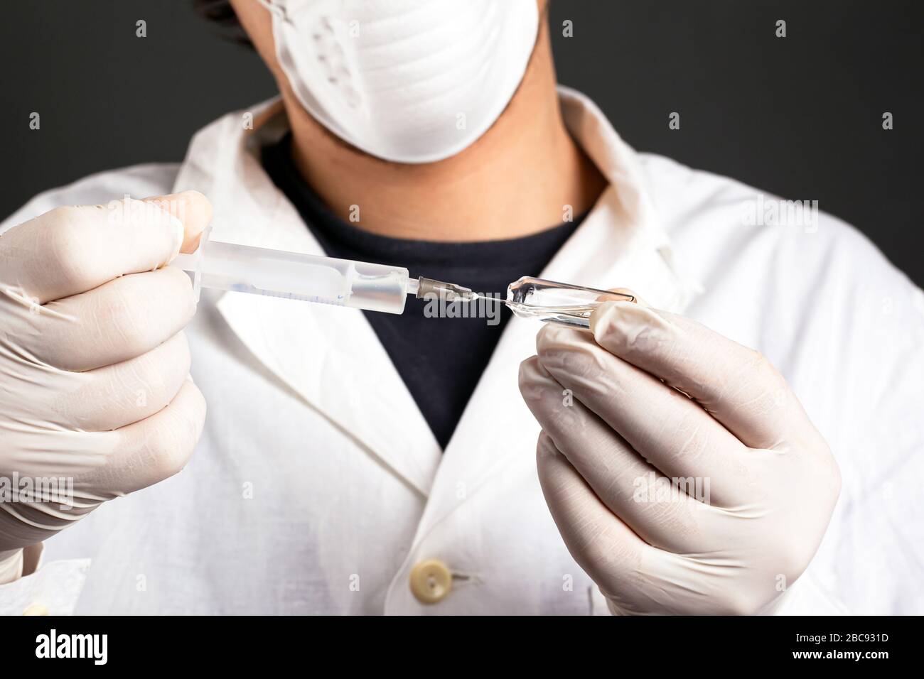 il medico preleva il medicinale da una fiala in una siringa vaccinazione contro l'influenza, il coronavirus pandemico covid-19. Foto Stock