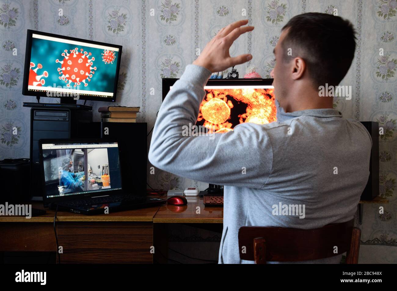 Krasnodar, Russia - 02 aprile 2020: Un uomo siede ai monitor del computer ed è orridito dalle notizie circa la diffusione del coronavirus. Covid 19 Foto Stock