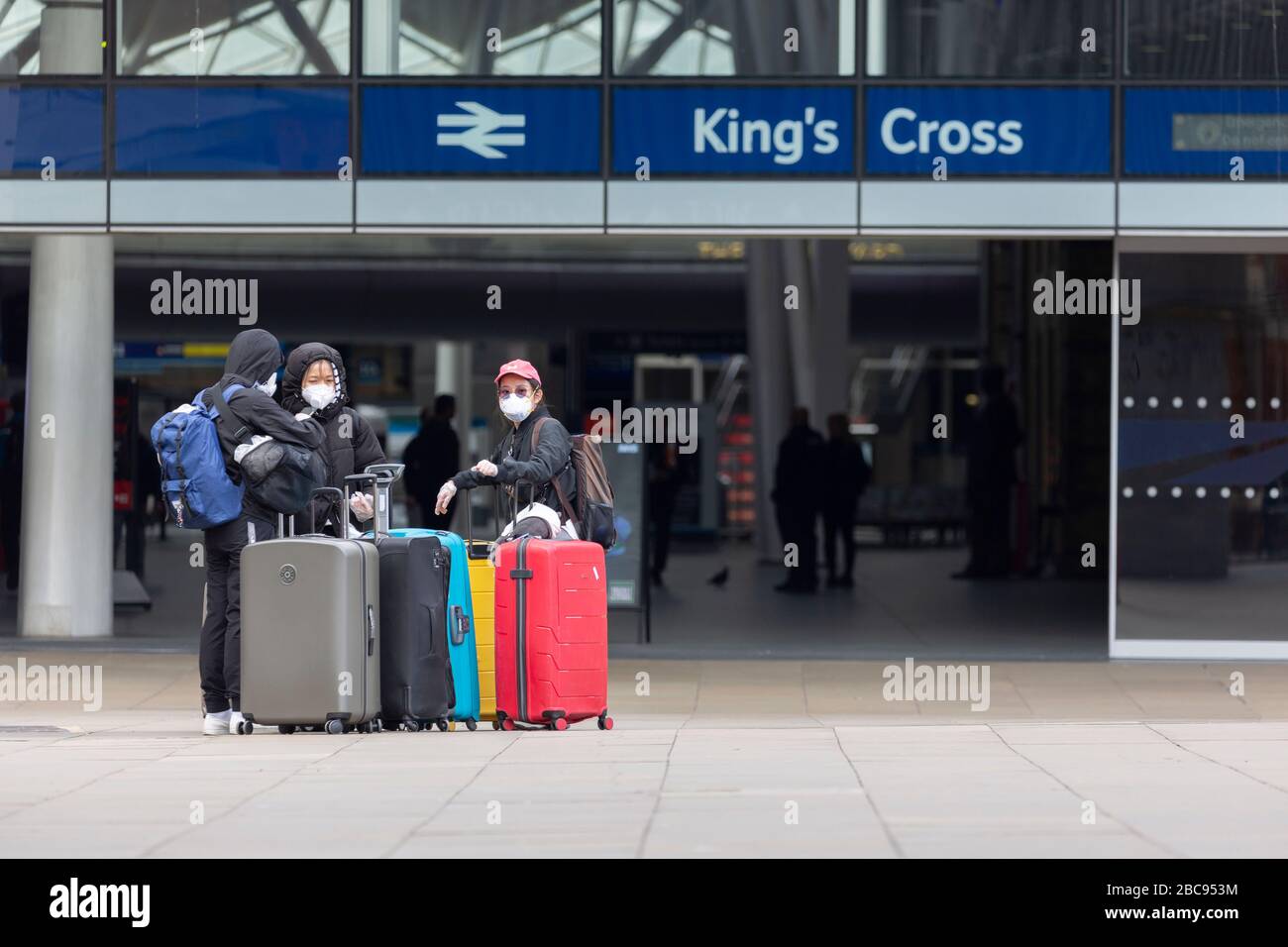 Londra, Regno Unito. 03rd Apr, 2020. Un gruppo di viaggiatori stranieri con bagaglio a mano lascia la stazione ferroviaria London King's Cross indossando guanti protettivi e maschere facciali. Un totale di 3.605 persone è morto da Covid-19 coronavirus in tutto il Regno Unito durante la pandemia. Credito: Thamesfleet/Alamy Live News Foto Stock