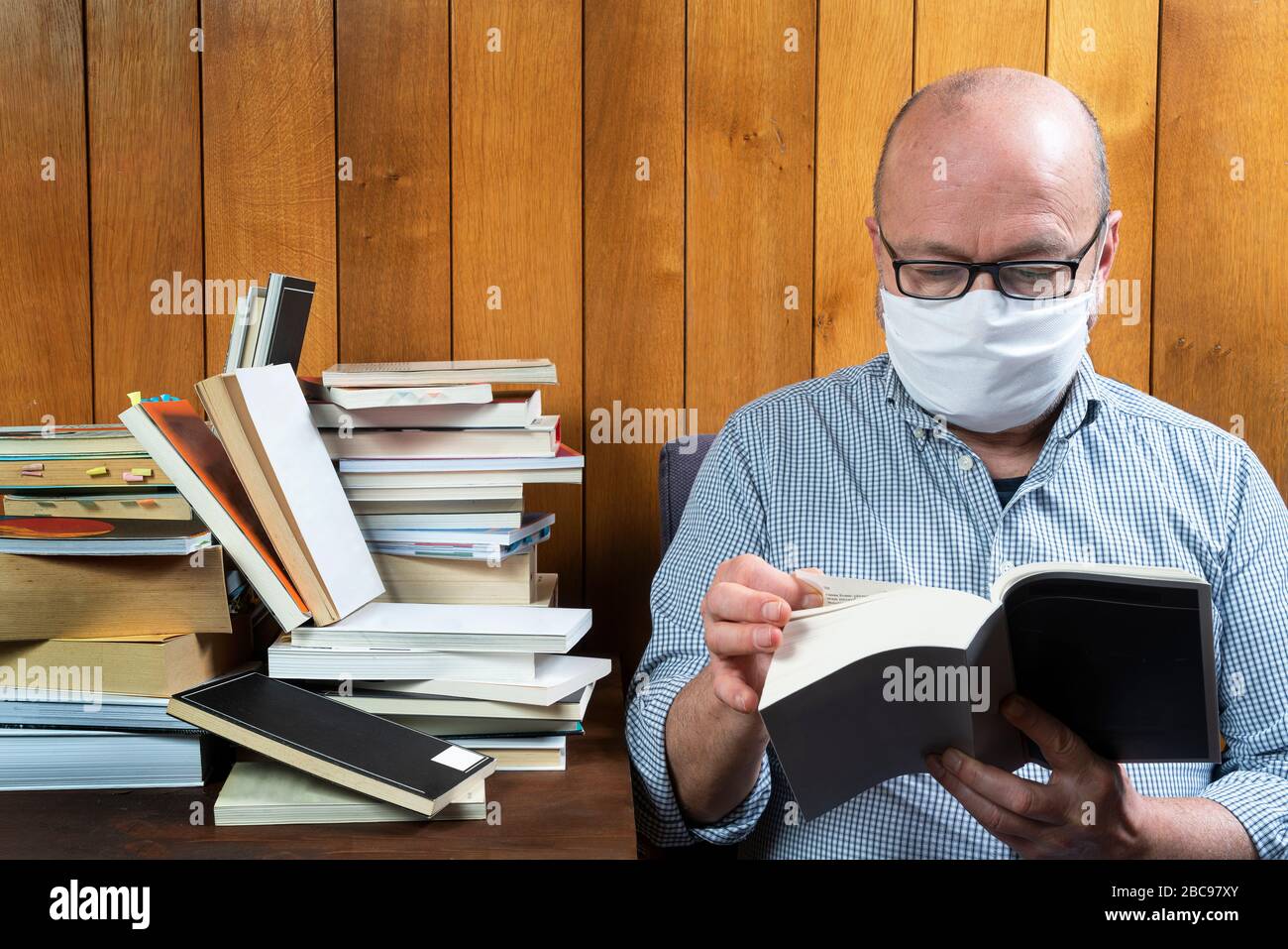 lettura di un libro durante il periodo di mantenimento della separazione sociale per il coronavirus Foto Stock