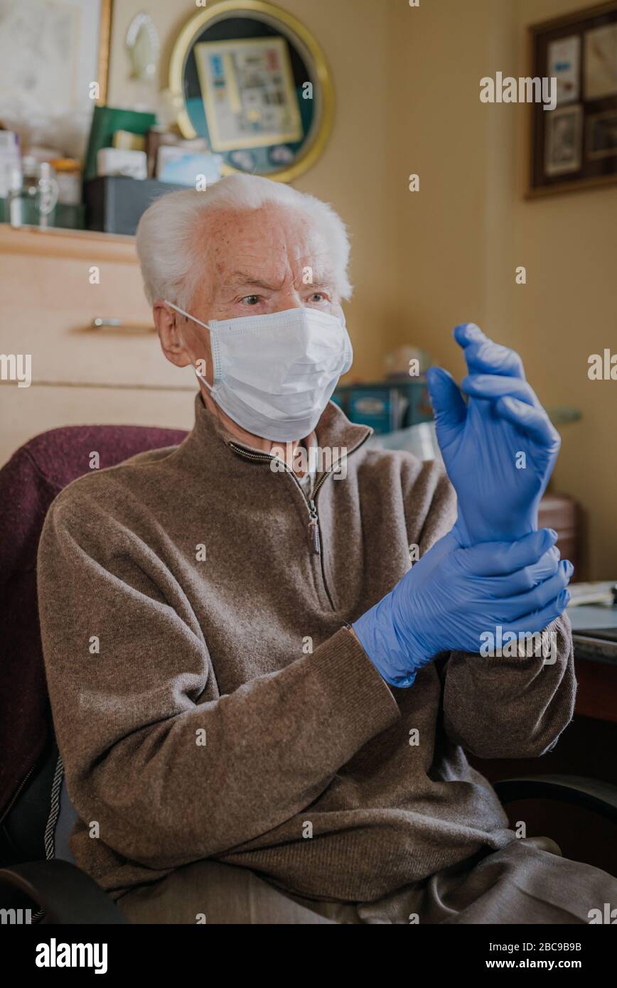 Ritratto senior in maschera protettiva e guanti a casa, coronavirus pandemico, covid-19 Foto Stock