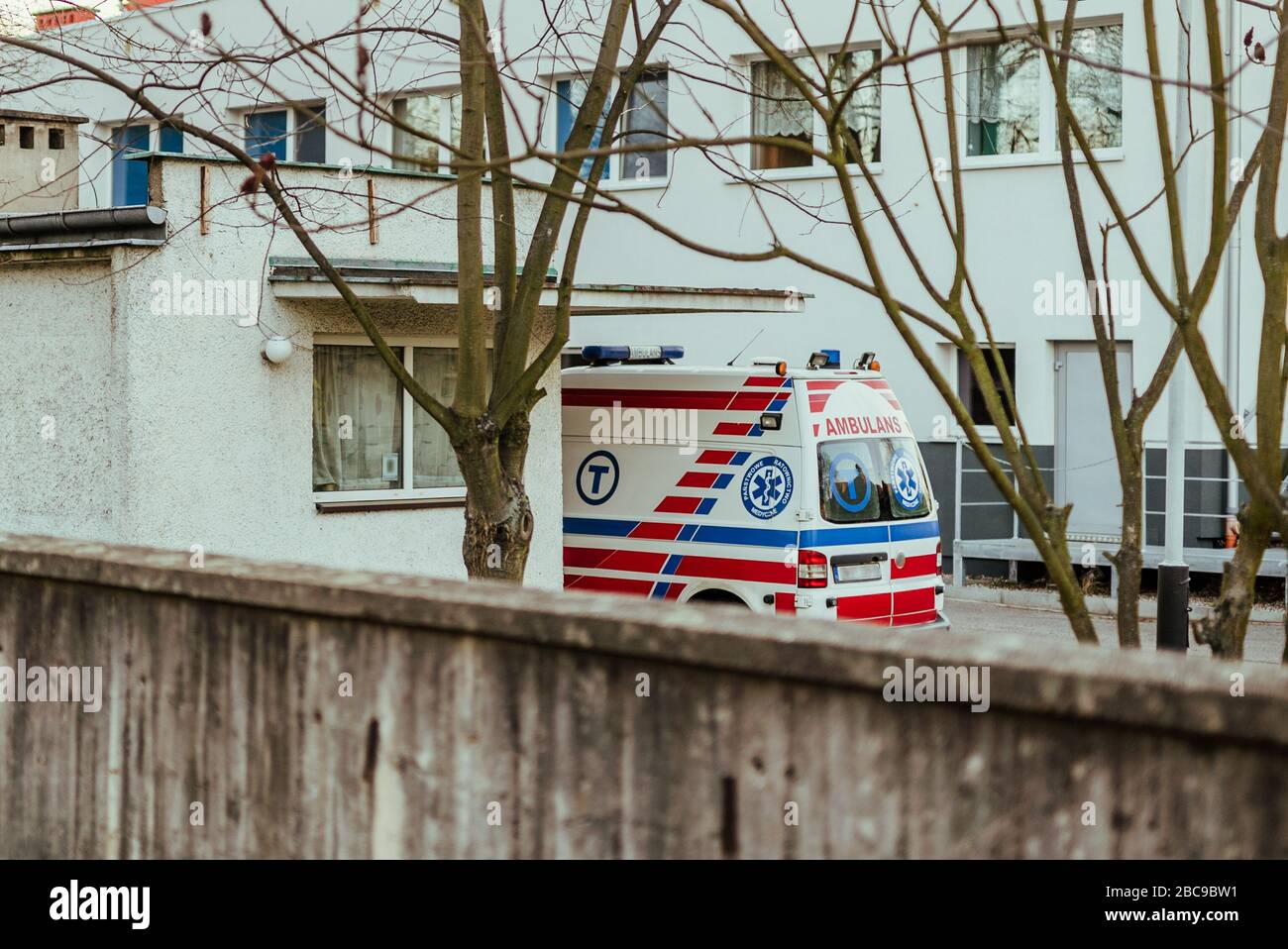 Chiamata urgente per l'ambulanza a incidente, parcheggiata ambulanza contro edificio ospedaliero - chiamata di emergenza Foto Stock