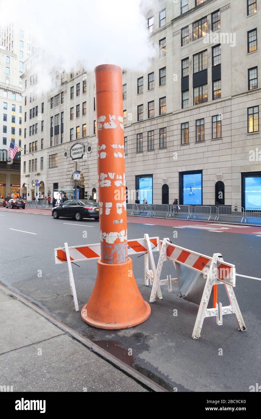 Barriere protettive intorno a un tubo che scarica vapore da una perdita nel sistema di riscaldamento a vapore di New York su 5th Avenue, New York Foto Stock